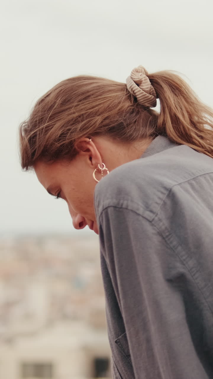Giovane donna pensierosa guarda in alto e sorride di profilo