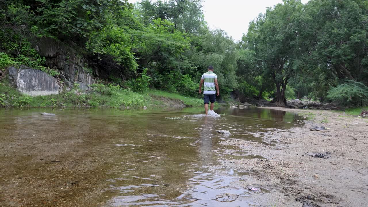 Isolated Man Walking in Natural River Stream During Morning