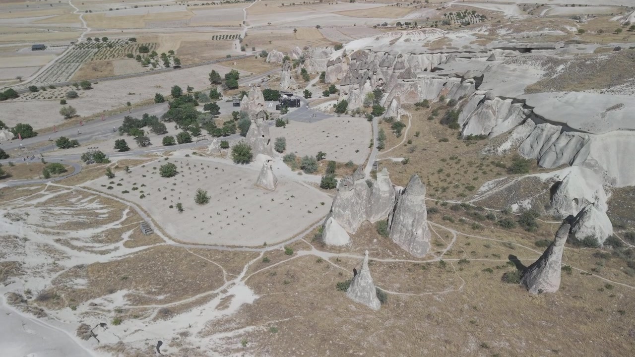 4K 10-bit top down drone shot over fairy chimneys and an outdoor concert stage venue in Cappadocia, Turkey. Sunny summer day aerial panoramic footage of the unique festival site.