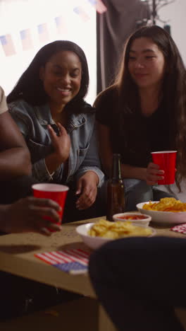 Video-Vertical-De-Amigos-En-Casa-Riendo-Hablando-Y-Comiendo-Bocadillos-Celebrando-En-Una-Fiesta-Haciendo-Brindis-Con-Alcohol-1