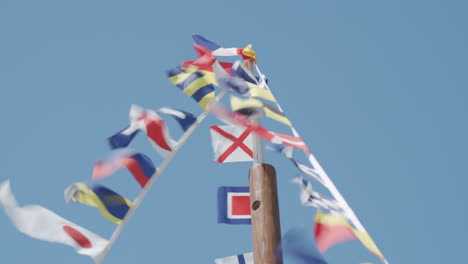 Pequeñas-Banderas-En-El-Poste-Ondeando-En-El-Viento