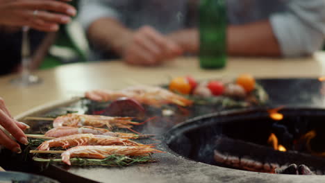 mujer cocinando mariscos en la parrilla