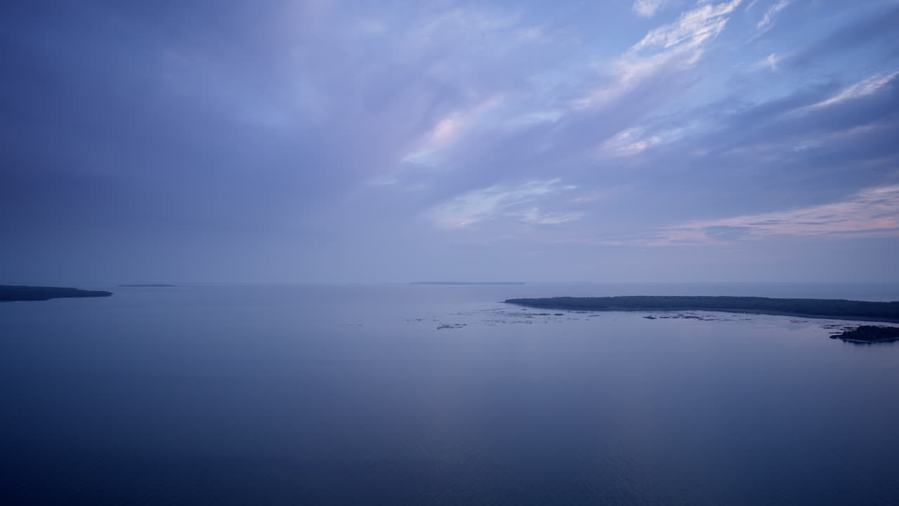 Drone shot panning from little summer island back to the garden peninsula on color summer evening.
