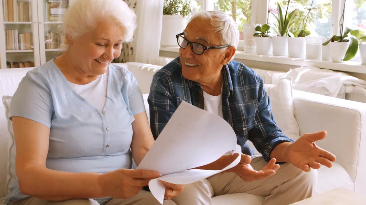 pareja de ancianos interactuando mientras comprueban las facturas