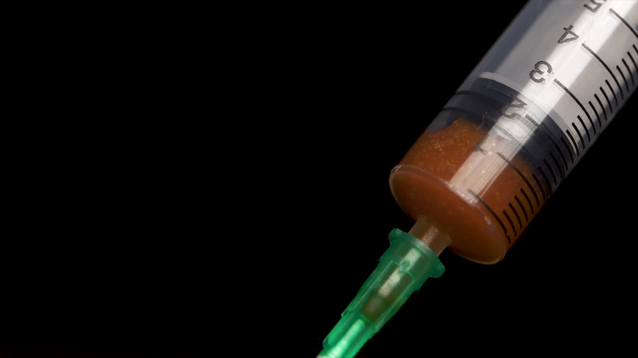 jeringuilla con líquido naranja