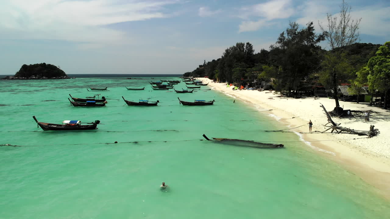 vuelo sobre barcos anclados en una playa de aguas claras