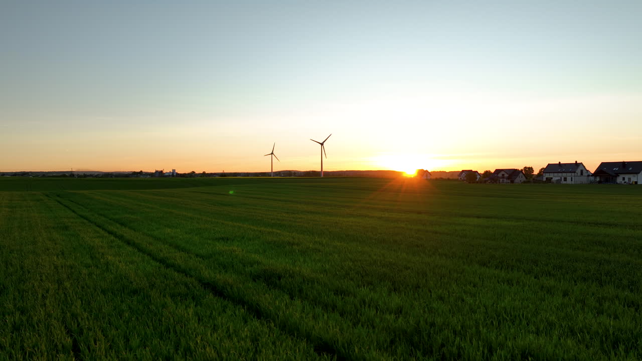 해가 지는 동안 카놀라 에 있는 농장과 풍력 터빈의 시골 장면