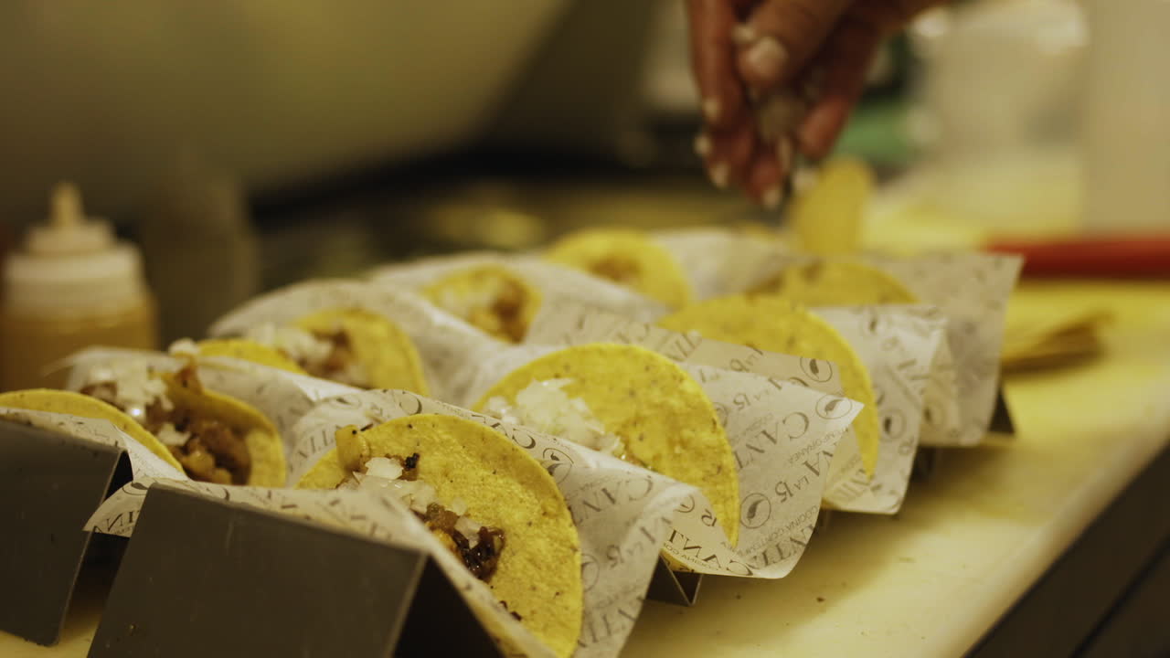 I de sidste trin af madlavningen færdiggøres tacos'ene dygtigt og serveres med en lækker sauce.