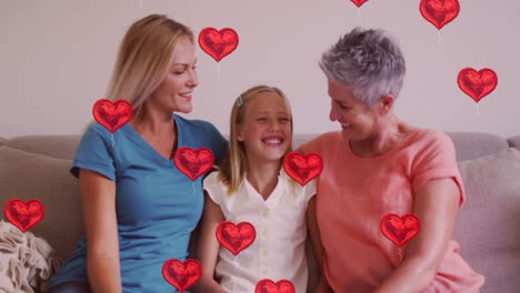 animación de globos de corazón rojo sobre tres personas sonrientes sentadas en el sofá