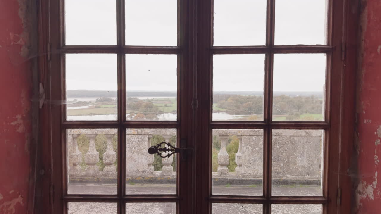 View of the historic Château du Bouchet grounds through a wooden window in Rosnay, France
