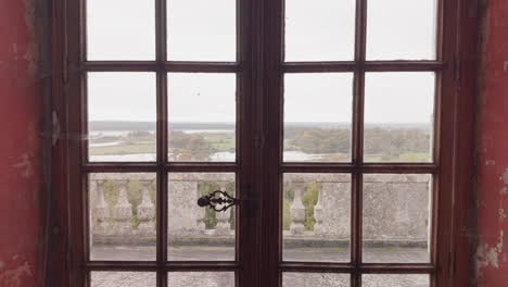 view of the historic château du bouchet grounds through a wooden window in rosnay, france