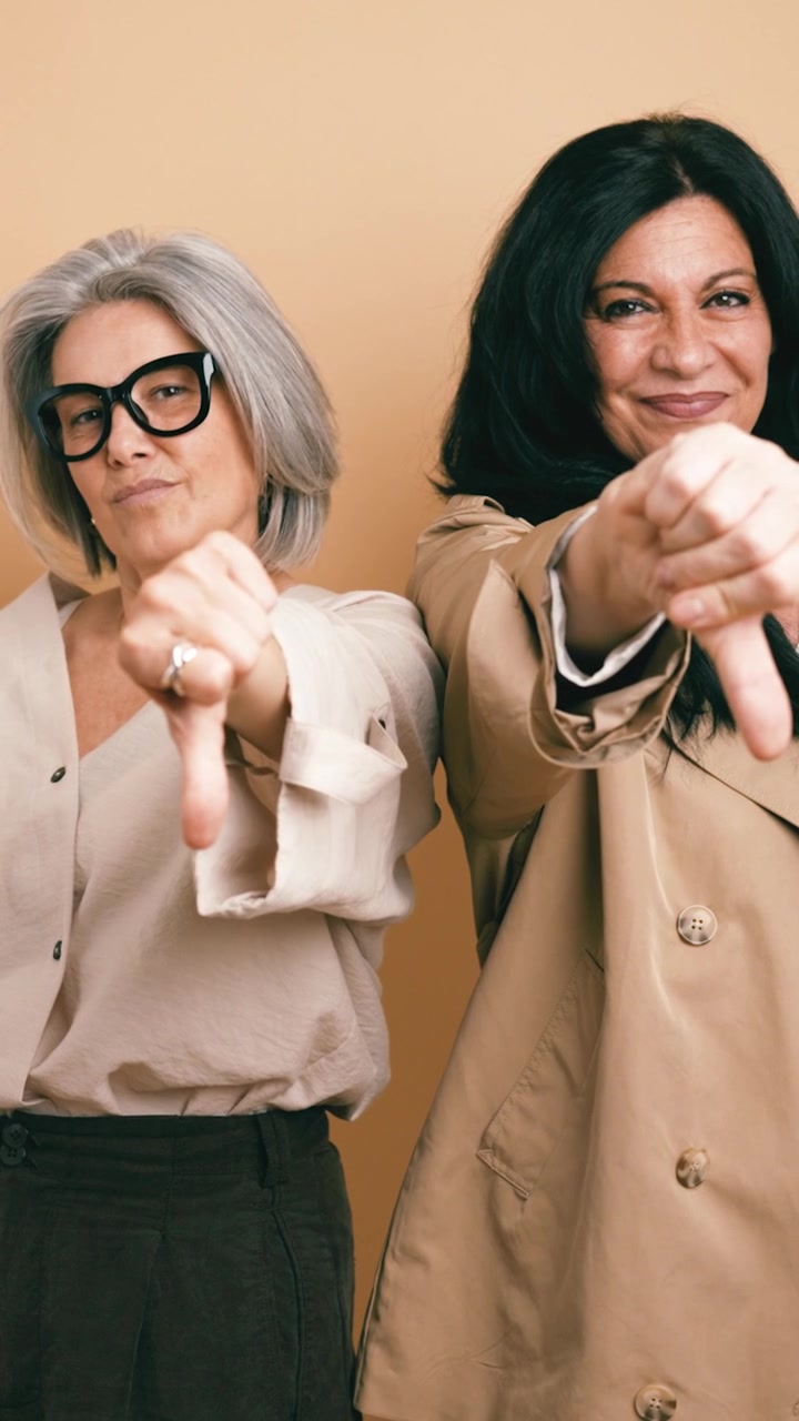 Two Mature Women Giving Thumbs Down Gesture