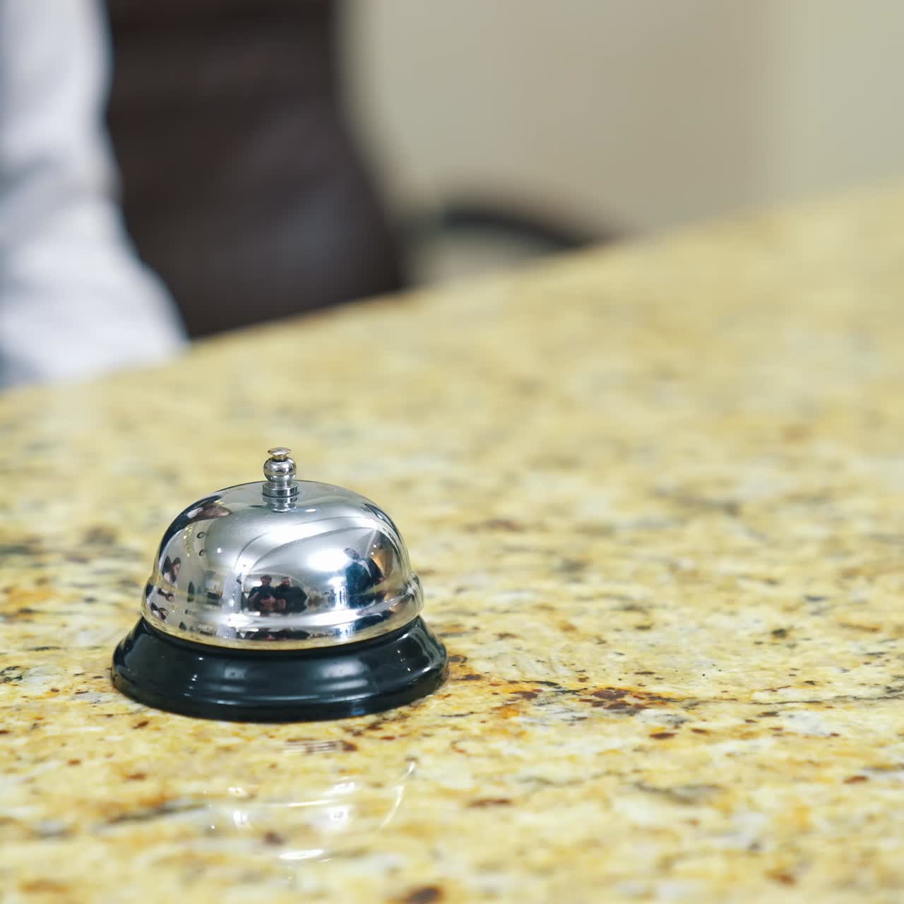 Guest makes card payment at check-in. Bell at hotel reception. Man in hotel lobby pay with nfc chip card. Blurred video of payment with terminal during checking in