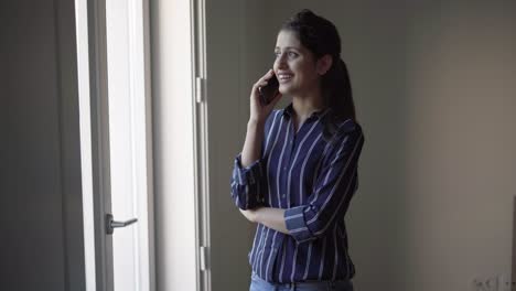 chica latina positiva teniendo una buena conversación telefónica