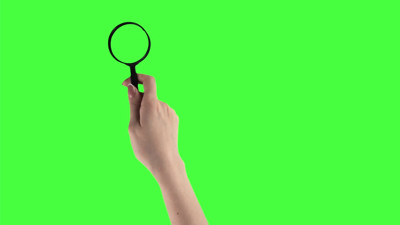 las manos del hombre y la mujer están sosteniendo una lupa y moviéndola en un fondo de pantalla verde