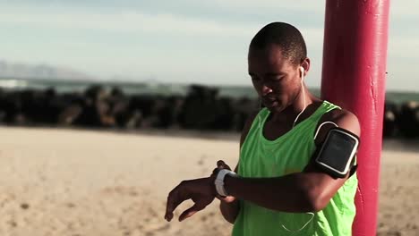 Hombre-Usando-Reloj-Inteligente-En-La-Playa