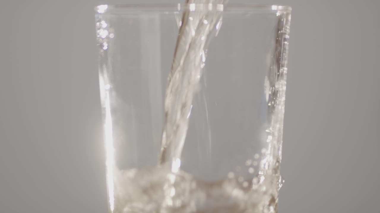 맛있는 알코올성 사과 사이드가 깨 ⁇ 한 유리잔에 부어지고 있습니다.