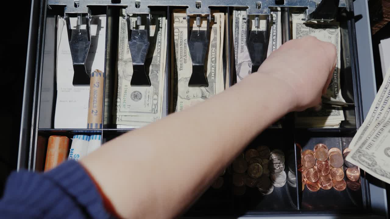 una cajera trabaja con efectivo y efectivo, sólo las manos son visibles en el marco