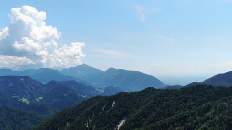 aerial view with epic clouds and forests on mount prevala, slovenia