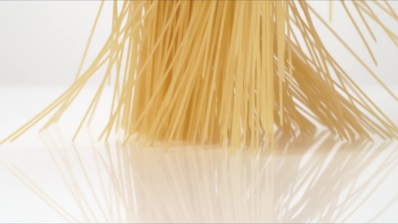 Spaghetti secchi non cotti, Capelli d'angelo, Linguine che rimbalzano su un tavolo bianco in slow motion, primo piano macro prima di posarsi