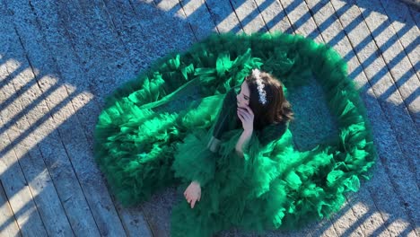 women sitting outdoors with a green dress posing for a photographer