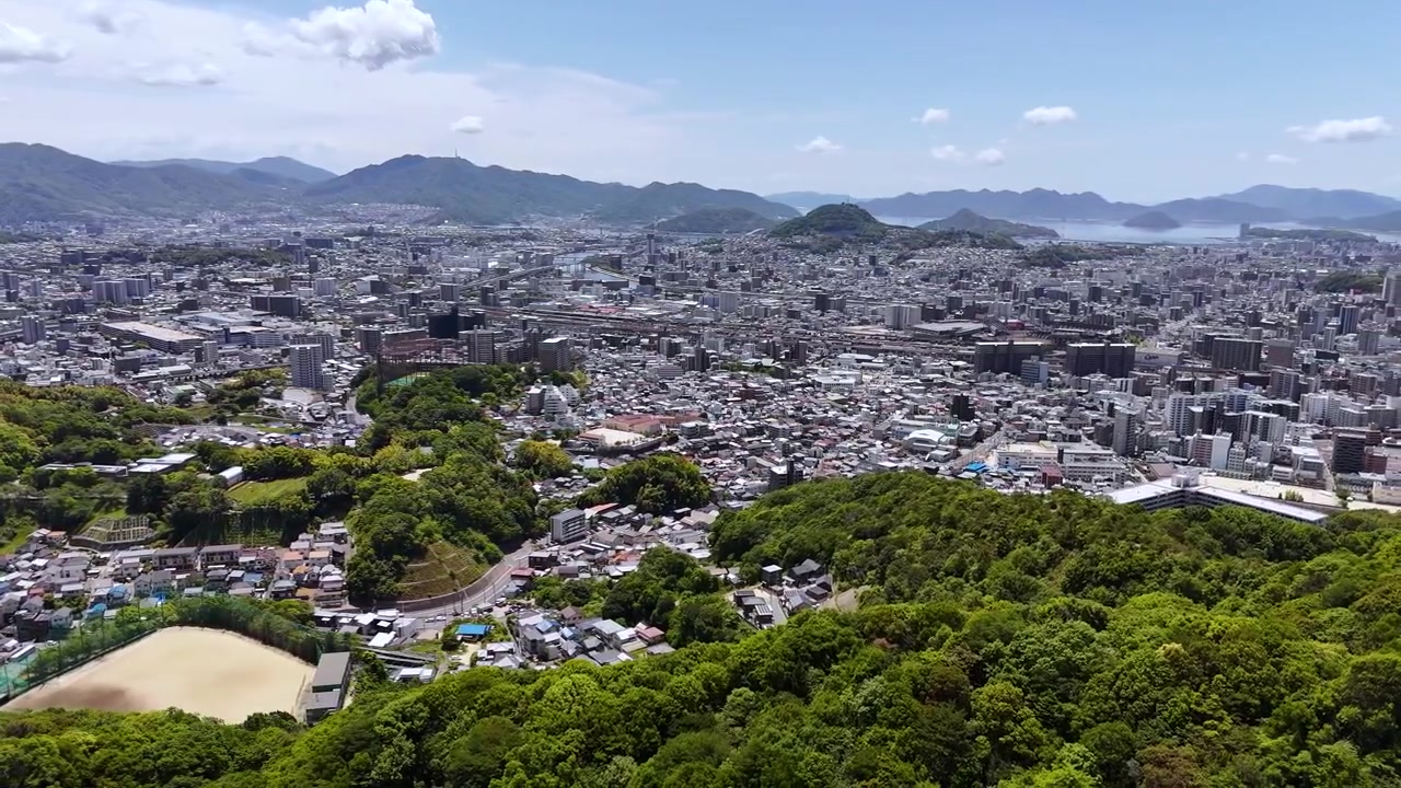 Volando lateralmente sopra una fitta foresta, vista di Hiroshima (1 di 2)