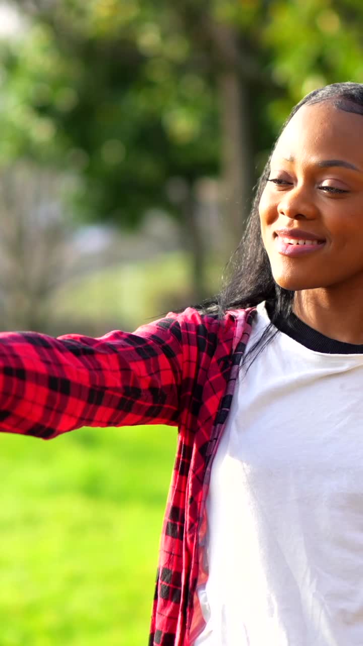 Donna con camicia a quadri che si fa un selfie o realizza un vlog nel parco