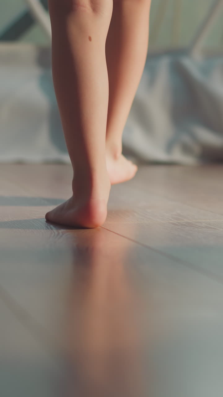Child feet move towards white wall of tourist tent. Barefoot boy approaches light window closeup slow motion. Little tourist rests in glamping place on blurred background