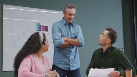 Happy-diverse-business-people-discussing-work-during-meeting-at-office