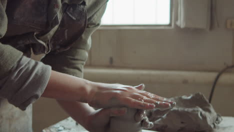 female potter wheel throwing in workshop