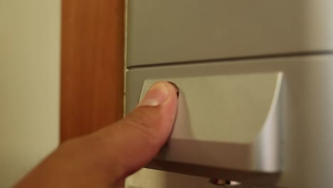 man uses fingerprint scanner to unlock door