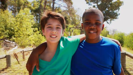 retrato de niños felices de pie con los brazos alrededor en el campamento de entrenamiento