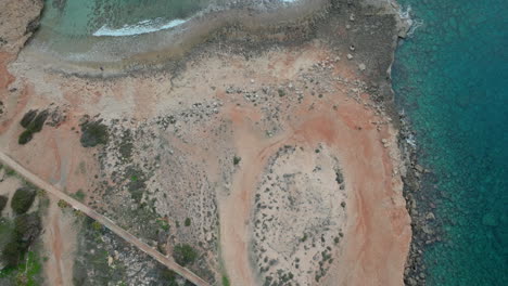 aerial top down view of ayia napa rocky pebble beach and turquoise clear water sea in cyprus