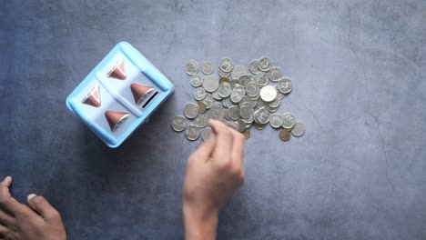 saving money: putting coins in a piggy bank