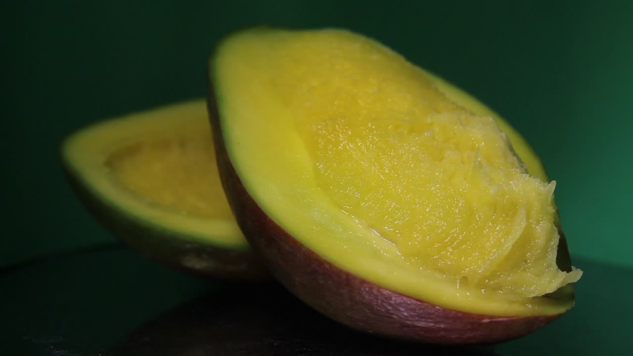 mitad de mango en el fondo oscuro y verde