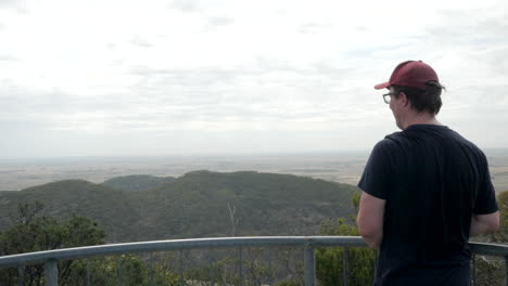 man looks out over the you yangs national park, victoria australia