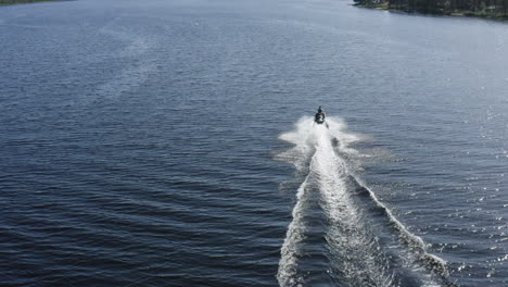 Aerial-view-of-a-youn-man-speeding-on-a-jet-ski