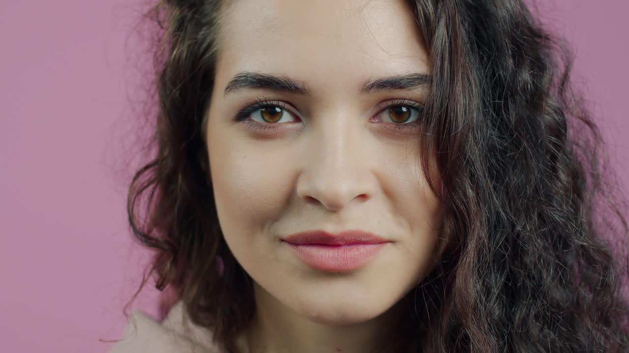 Woman with curly hair and playful expression