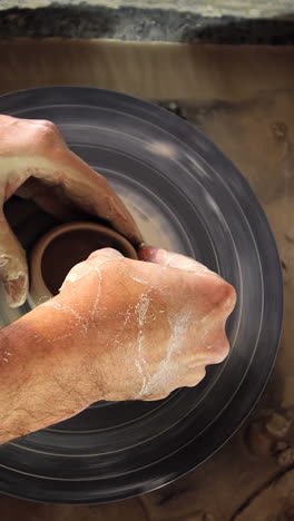 male potter making pot