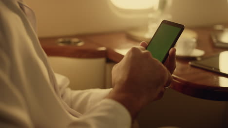 Passenger holding green cellphone in hands closeup. Manager texting chroma key