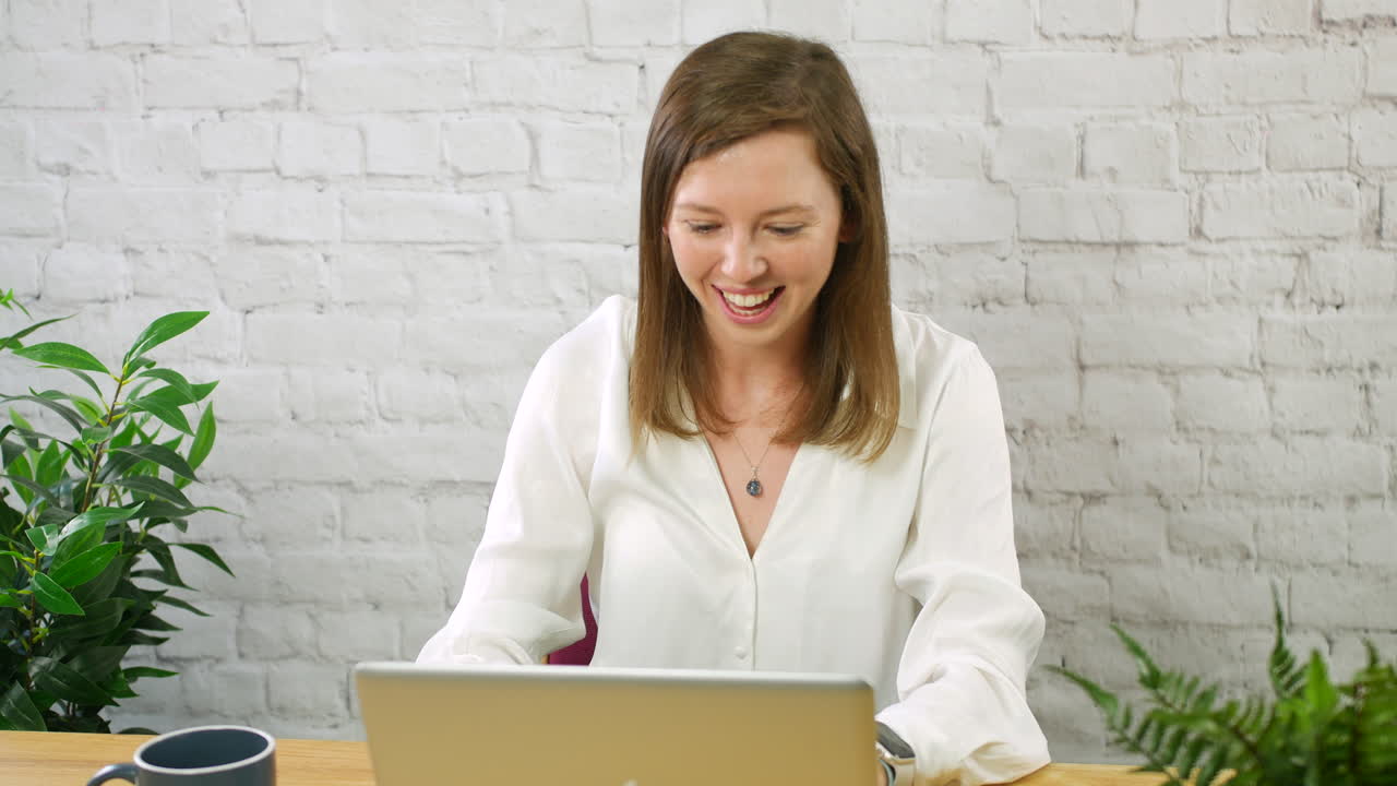 젊은 여성 사업가 여성은 노트북 컴퓨터에서 사무실에서 승리