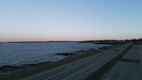 car drives along ocean avenue in newport rhode island at sunrise