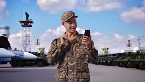 military personnel using smartphone at airbase