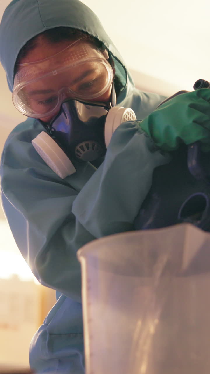 A person wearing a protective suit and mask in a lab setting
