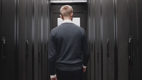 técnico hombre caminando más allá de la sala de servidores del centro de datos en cámara lenta