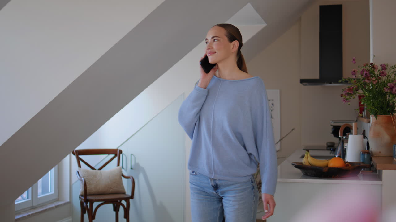 Calm woman chatting cell kitchen looking window closeup. Lady talking smartphone