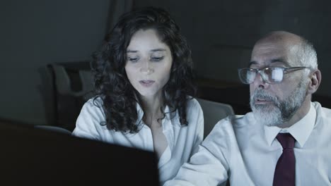 hombre de negocios y mujer de negocios discutiendo el trabajo en la oficina oscura
