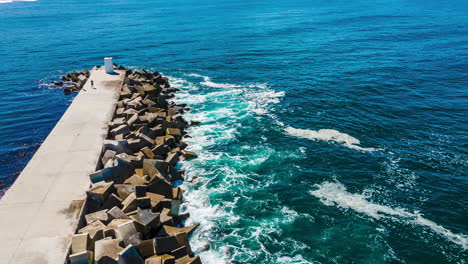 Aerial-hyperlapse-of-waves-crashing-into-reinforced-concrete-dolosse-at-pier