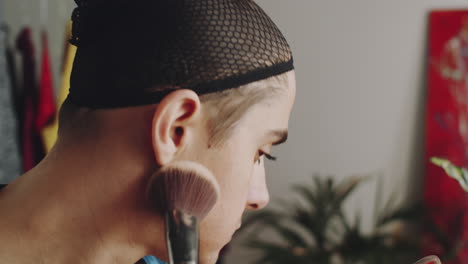 transgender man applying powder with brush