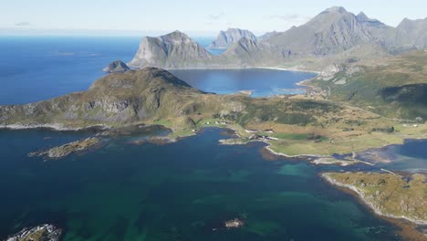 Volando-Sobre-Dos-Personas-Paradas-Al-Borde-De-La-Montaña-Offersoykammen-En-Lofoten-Noruega-Con-Vista-Panorámica-Sobre-El-Océano-Y-Las-Montañas-Circundantes